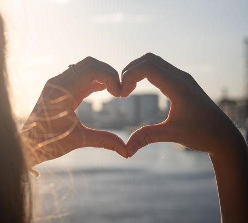 A silhouette of a person stretching against a soft sunrise background.